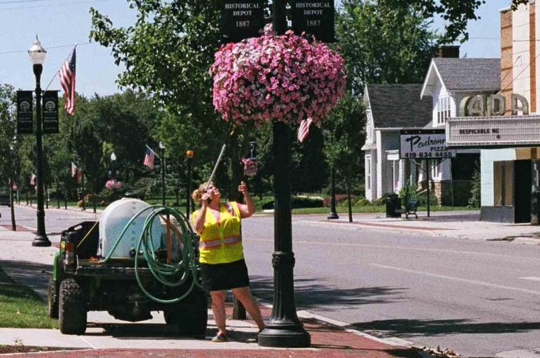 Hanging baskets on Main Street being watered