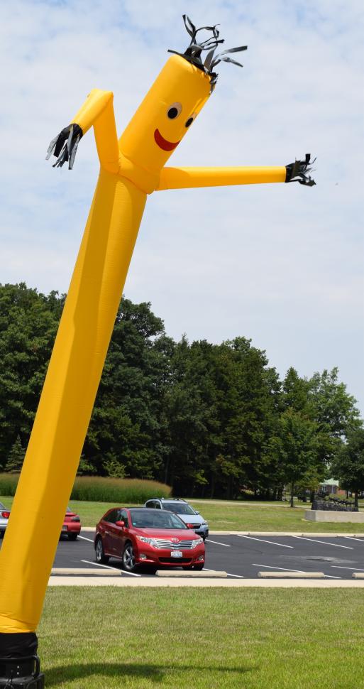 Riders are welcomed by Mr. Banana Man at the end of the day as they approach the finish line.