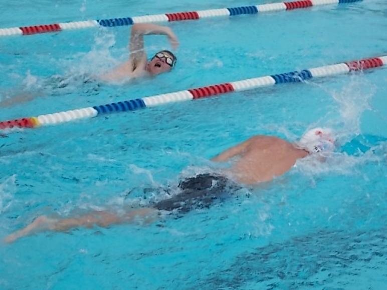 Two boy swimmers duel in the 50 freestyle.
